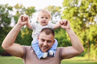 Photo of Smiling dad and his newborn baby outdoors. Happy Father's Day