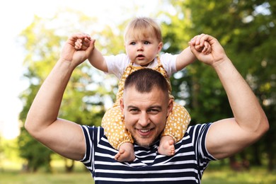 Photo of Smiling dad and his newborn baby playing outdoors. Happy Father's Day