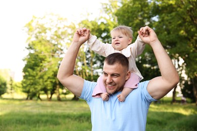 Photo of Smiling dad and his newborn baby playing outdoors. Happy Father's Day