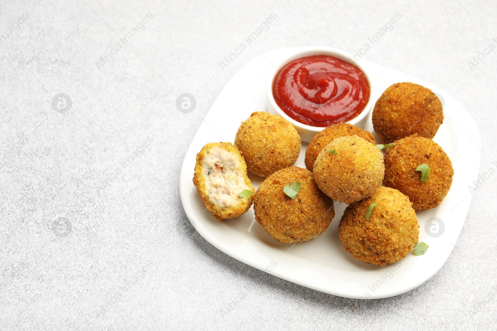Delicious fried croquette balls with parsley and ketchup on grey textured table, closeup. Space for text Photo of Delicious fried croquette balls with parsley and ketchup on grey textured table, closeup. Space for text