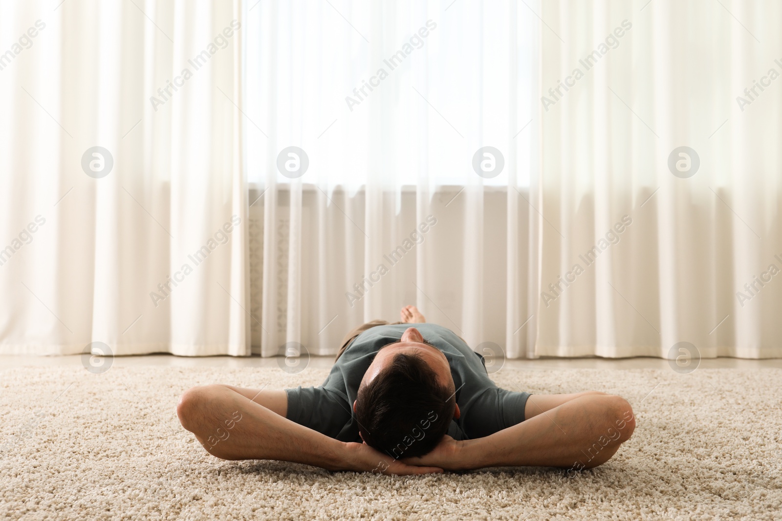 Harmony. Man lying on rug at home Photo of Harmony. Man lying on rug at home