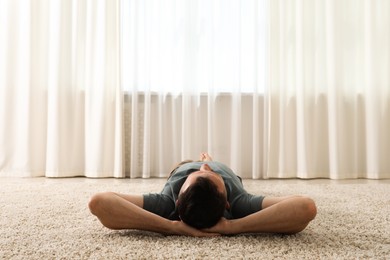 Photo of Harmony. Man lying on rug at home
