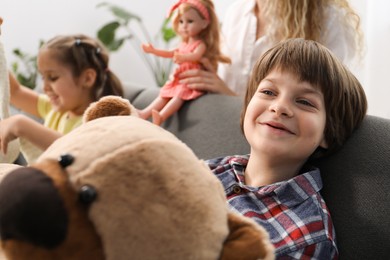 Photo of Children and their mother playing with different toys on sofa at home, selective focus