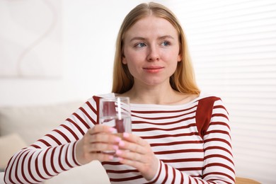 Photo of Young woman with glass of water at home