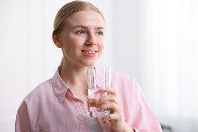 Photo of Young woman with glass of water at home