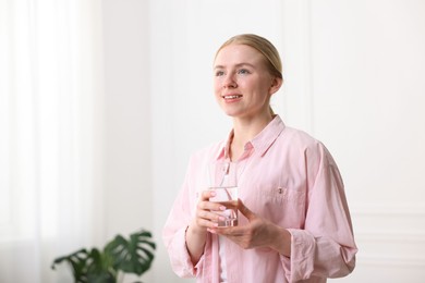 Photo of Young woman with glass of water at home