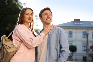 Photo of Lovely couple walking together on city street, low angle view