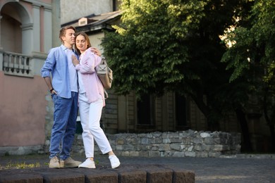 Photo of Lovely couple walking together on city street, space for text