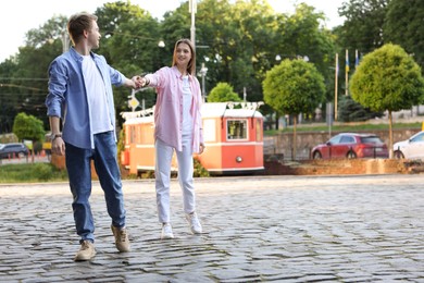 Photo of Lovely couple walking together on city street, space for text