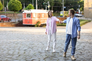 Photo of Lovely couple walking together on city street, space for text