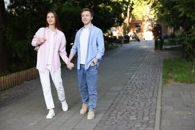 Photo of Lovely couple walking together on city street, space for text