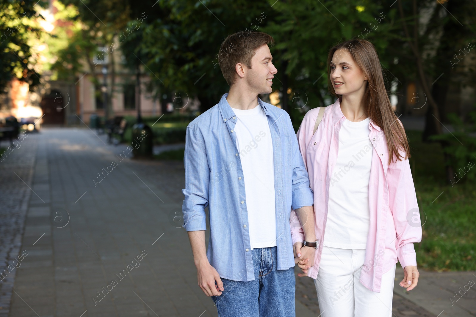 Lovely couple walking together on city street, space for text Photo of Lovely couple walking together on city street, space for text