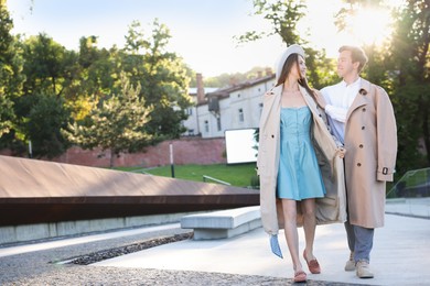 Photo of Lovely couple walking together on city street, space for text