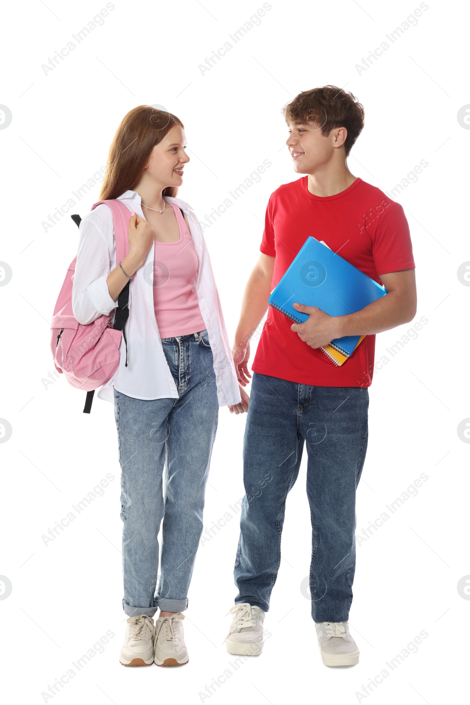 Teenage girl and boy with backpack and notebook on white background Photo of Teenage girl and boy with backpack and notebook on white background