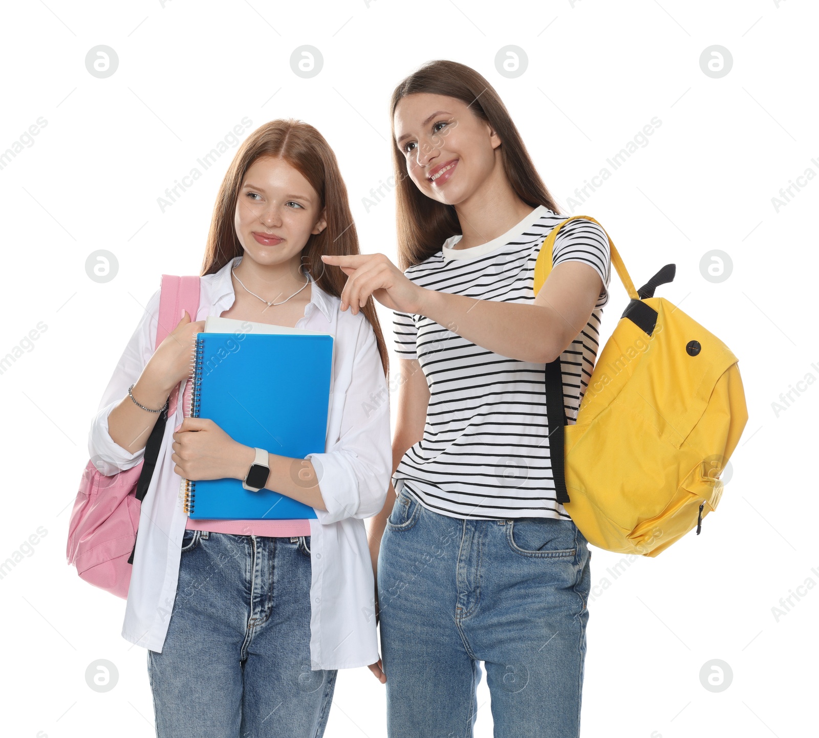 Teenage girl showing her friend something on white background Photo of Teenage girl showing her friend something on white background