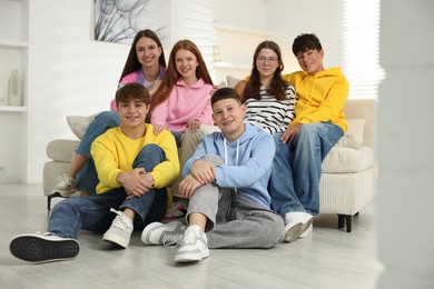 Photo of Group of happy teenagers on sofa at home