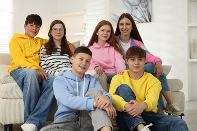 Photo of Group of happy teenagers on sofa at home