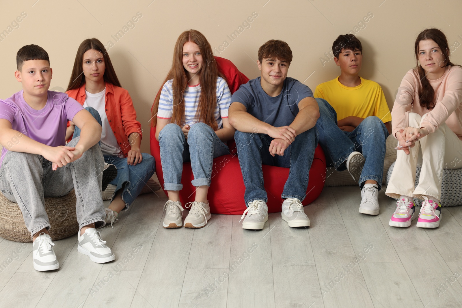 Group of happy teenagers on bean bags indoors Photo of Group of happy teenagers on bean bags indoors