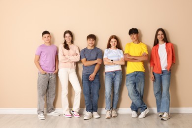 Photo of Group of teenagers near beige wall indoors