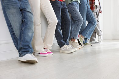 Photo of Group of teenagers near white wall indoors, closeup