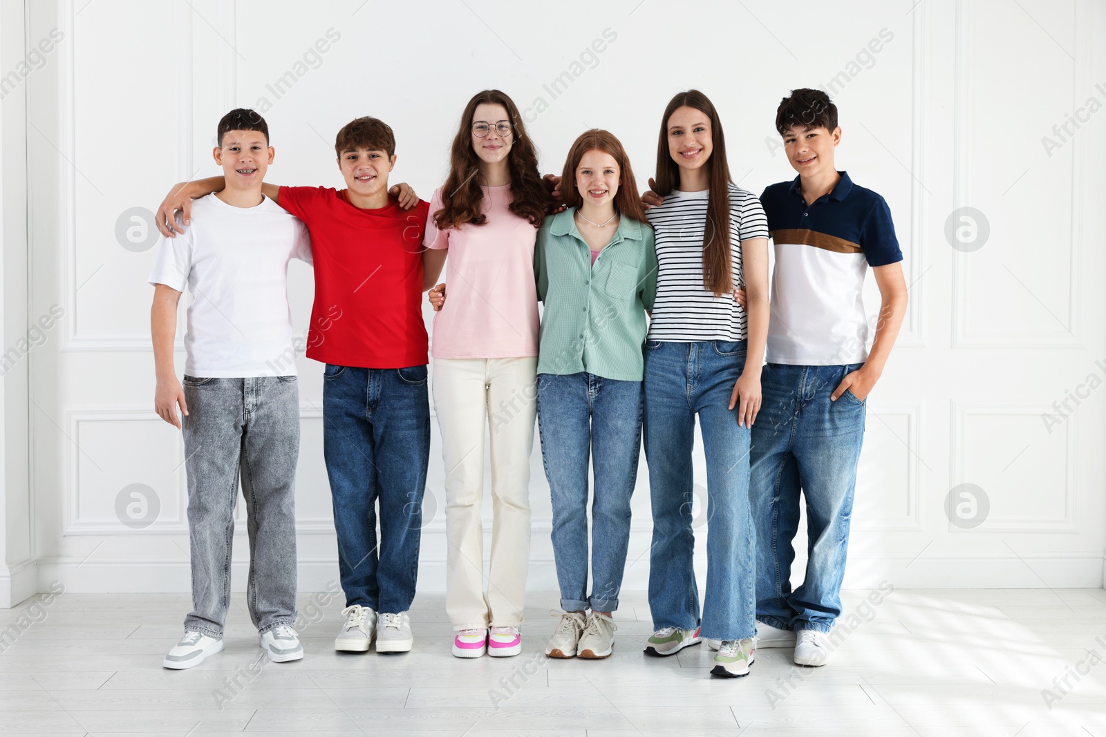 Group of happy teenagers posing together indoors Photo of Group of happy teenagers posing together indoors