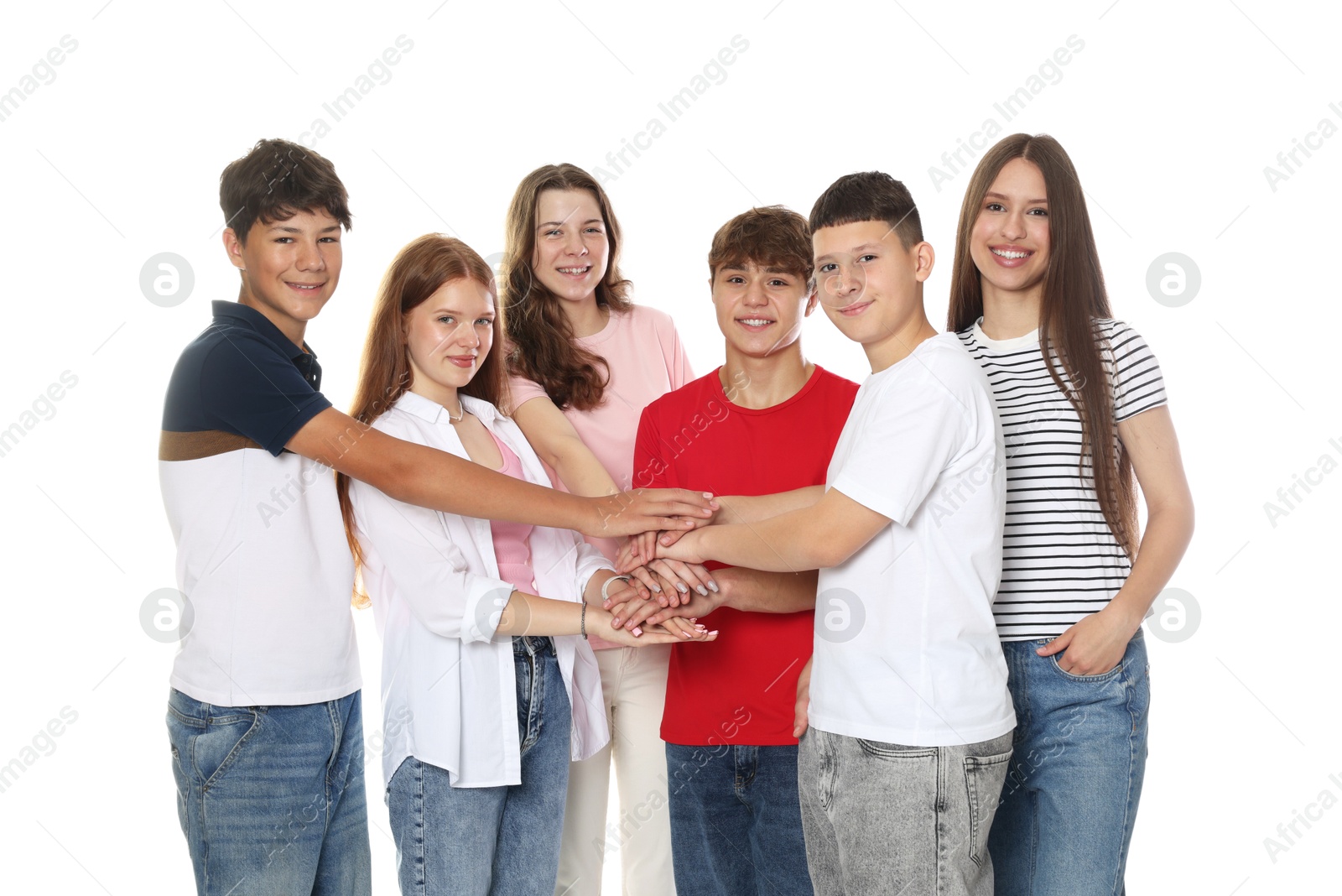 Group of happy teenagers joining hands on white background Photo of Group of happy teenagers joining hands on white background