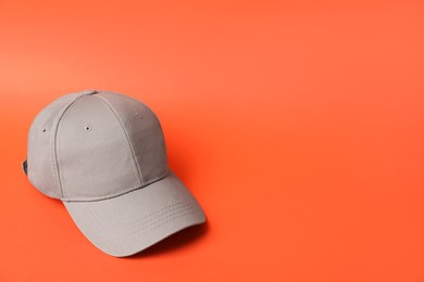Photo of Beige baseball hat on orange background, space for text