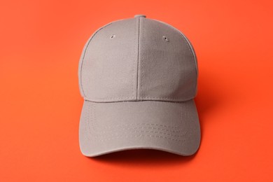 Photo of Beige baseball hat on orange background, closeup. Mockup for design