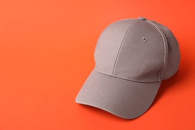 Photo of Beige baseball hat on orange background, space for text
