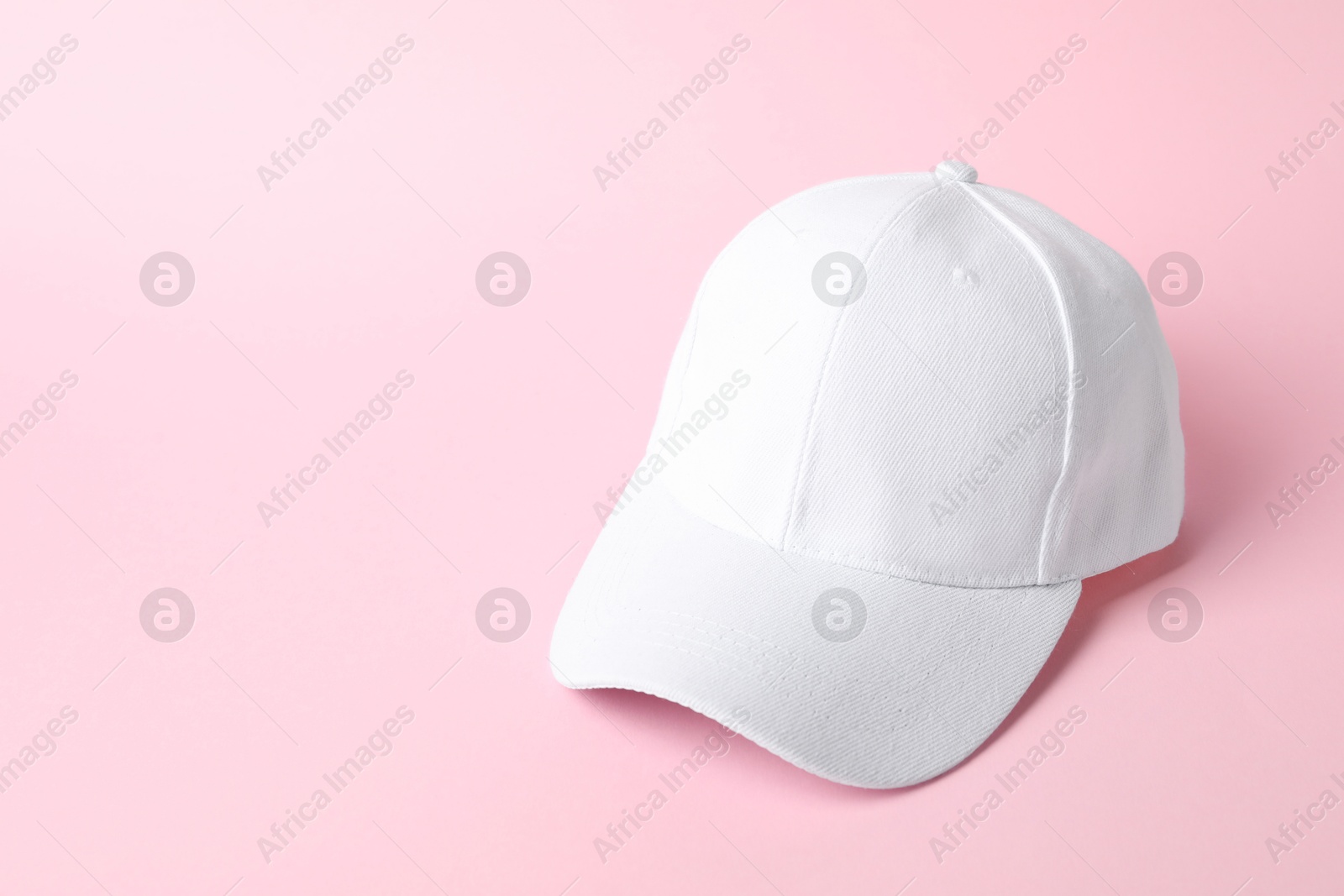 White baseball hat on pink background, space for text Photo of White baseball hat on pink background, space for text