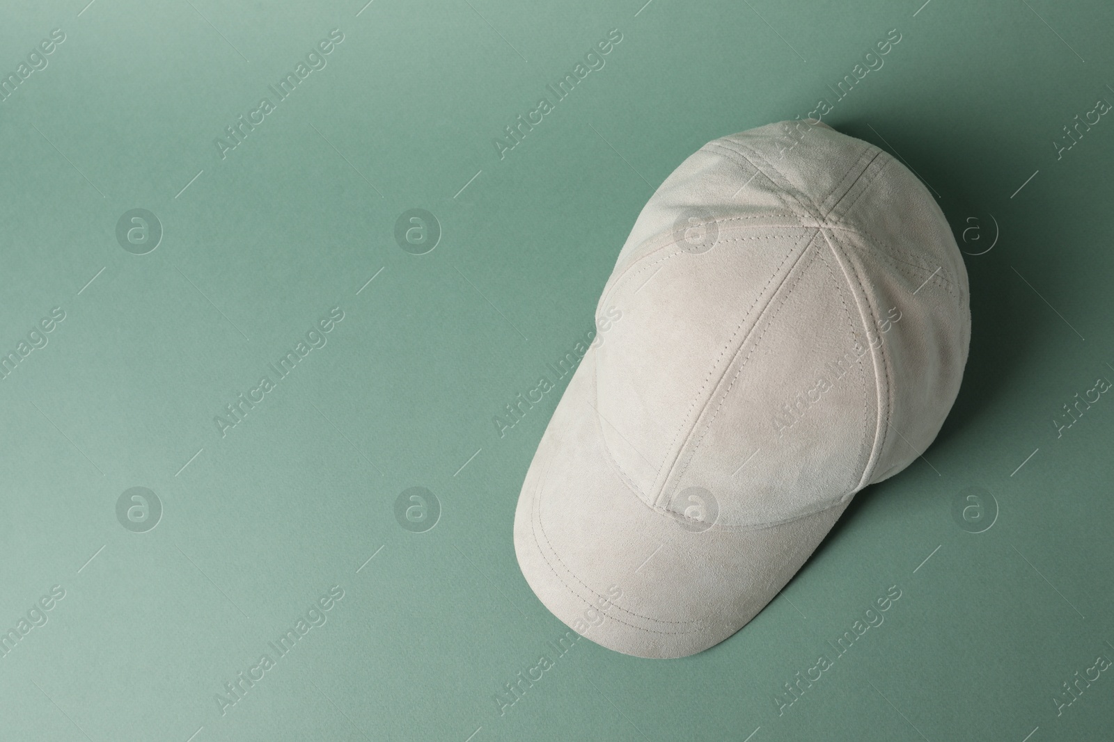 Beige baseball hat on green background, top view. Space for text Photo of Beige baseball hat on green background, top view. Space for text