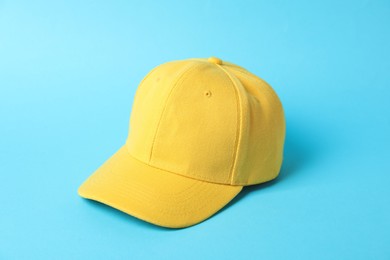 Photo of Yellow baseball hat on light blue background