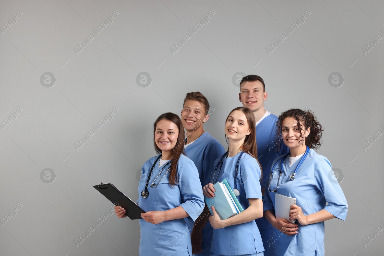 Group of medical students with books on light grey background. Space for text Photo of Group of medical students with books on light grey background. Space for text
