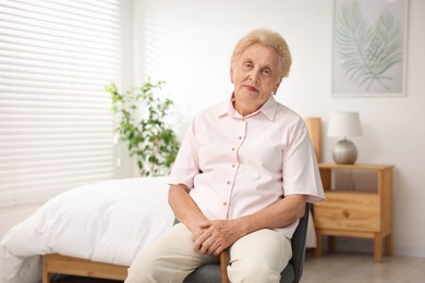 Photo of Senior woman with walking cane in armchair at home