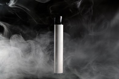 Photo of Modern electronic smoking device on black table
