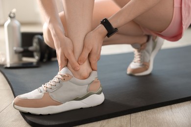 Photo of Sports injury. Young woman suffering from leg pain in fitness studio, closeup
