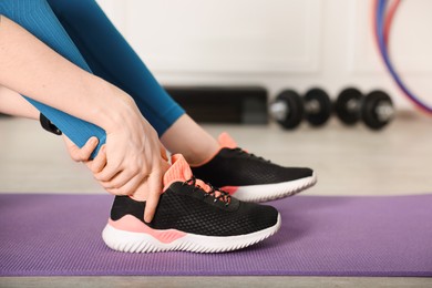 Photo of Sports injury. Young woman suffering from leg pain in fitness studio, closeup