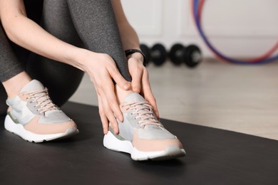Photo of Sports injury. Young woman suffering from leg pain in fitness studio, closeup
