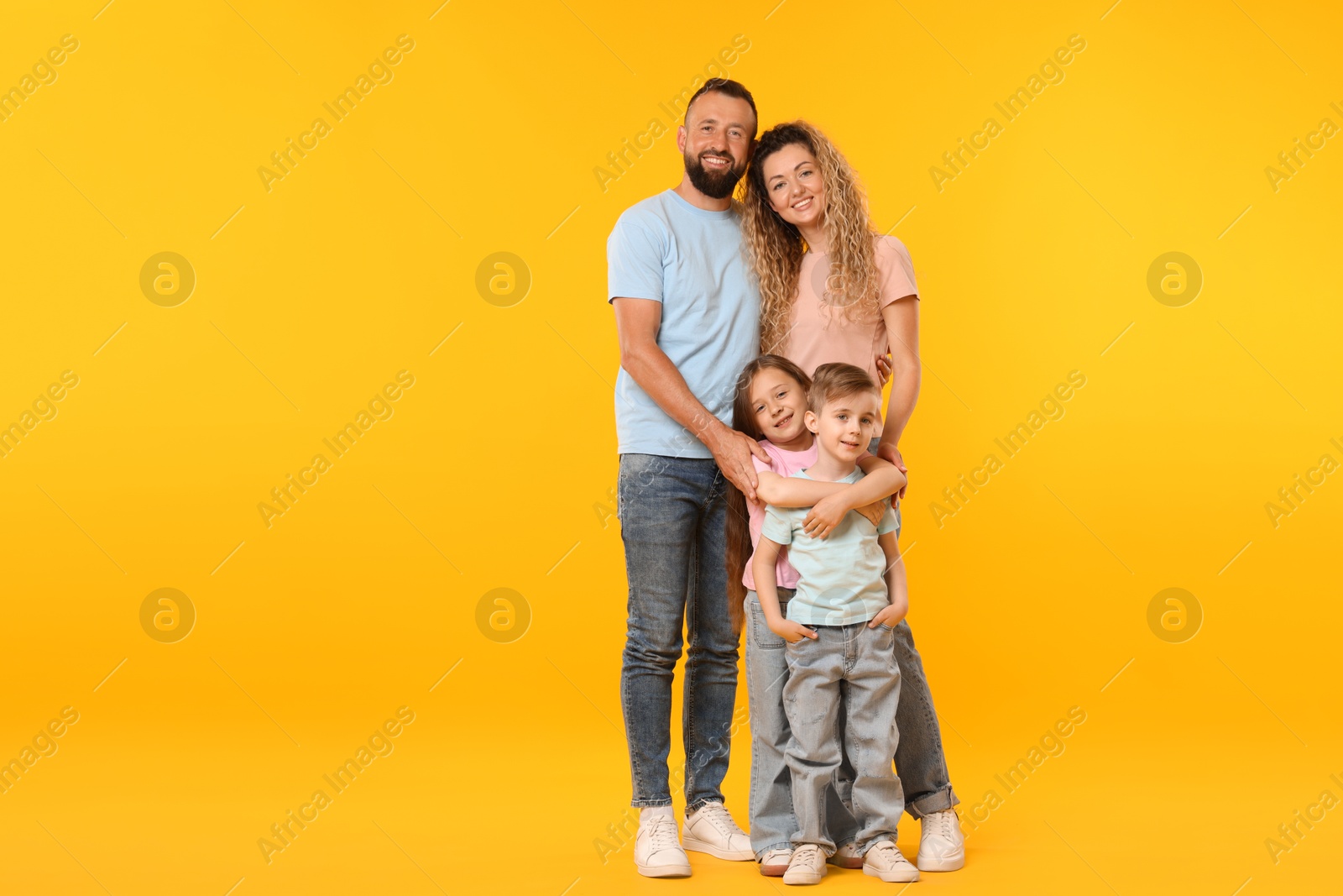 Happy family on yellow background. Space for text Photo of Happy family on yellow background. Space for text