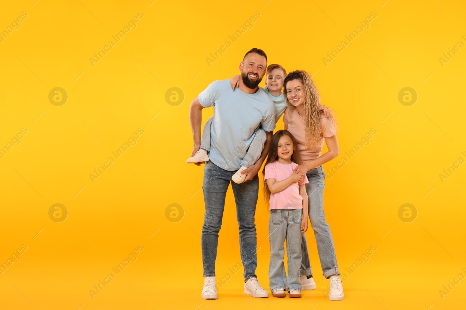 Happy family on yellow background. Space for text Photo of Happy family on yellow background. Space for text