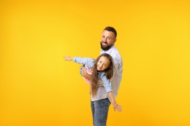 Photo of Family. Happy father and his daughter on yellow background