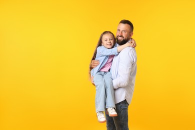 Photo of Family. Happy father and his daughter on yellow background. Space for text