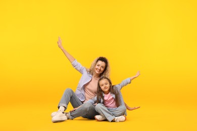 Photo of Family. Happy mother and her daughter on yellow background