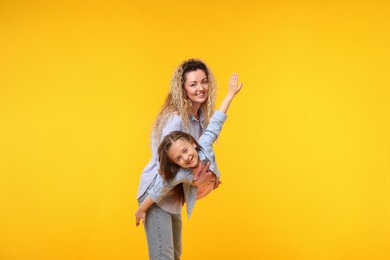 Photo of Family. Happy mother and her daughter on yellow background