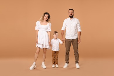 Photo of Family. Happy parents and their son on beige background