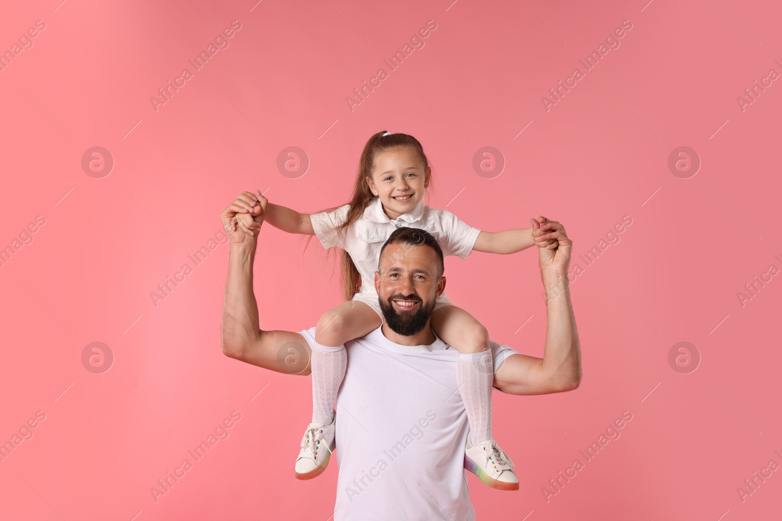Family. Happy father and his daughter on pink background Photo of Family. Happy father and his daughter on pink background