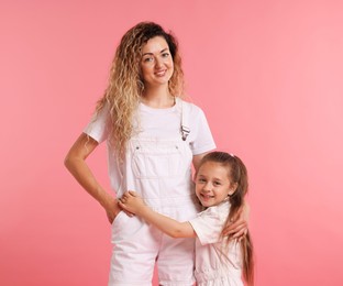 Photo of Family portrait of happy mother and her daughter on pink background