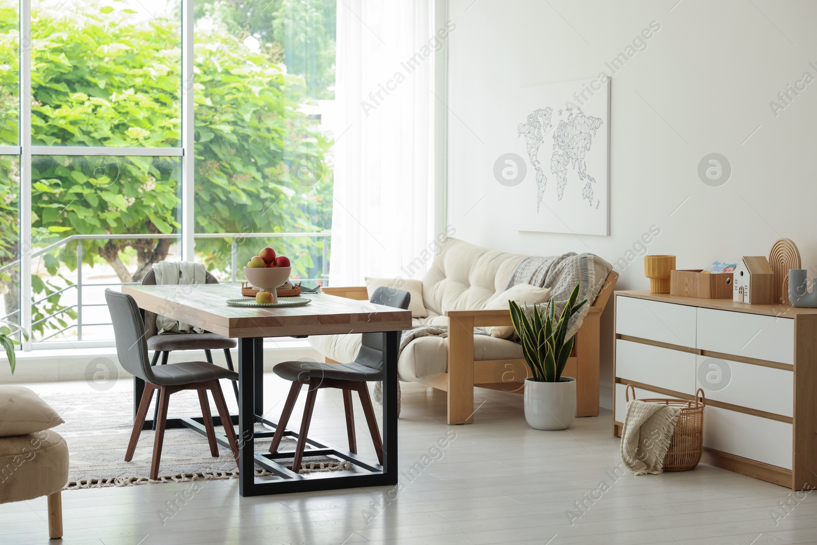 Wooden table, chairs, sofa and decor in dining room. Interior design Photo of Wooden table, chairs, sofa and decor in dining room. Interior design