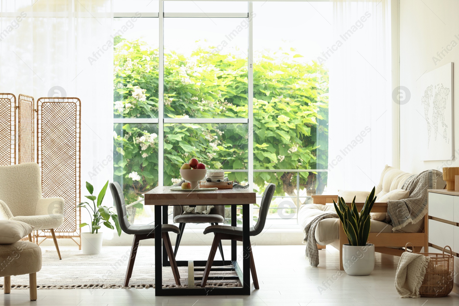 Wooden table, chairs, sofa and decor in dining room. Interior design Photo of Wooden table, chairs, sofa and decor in dining room. Interior design