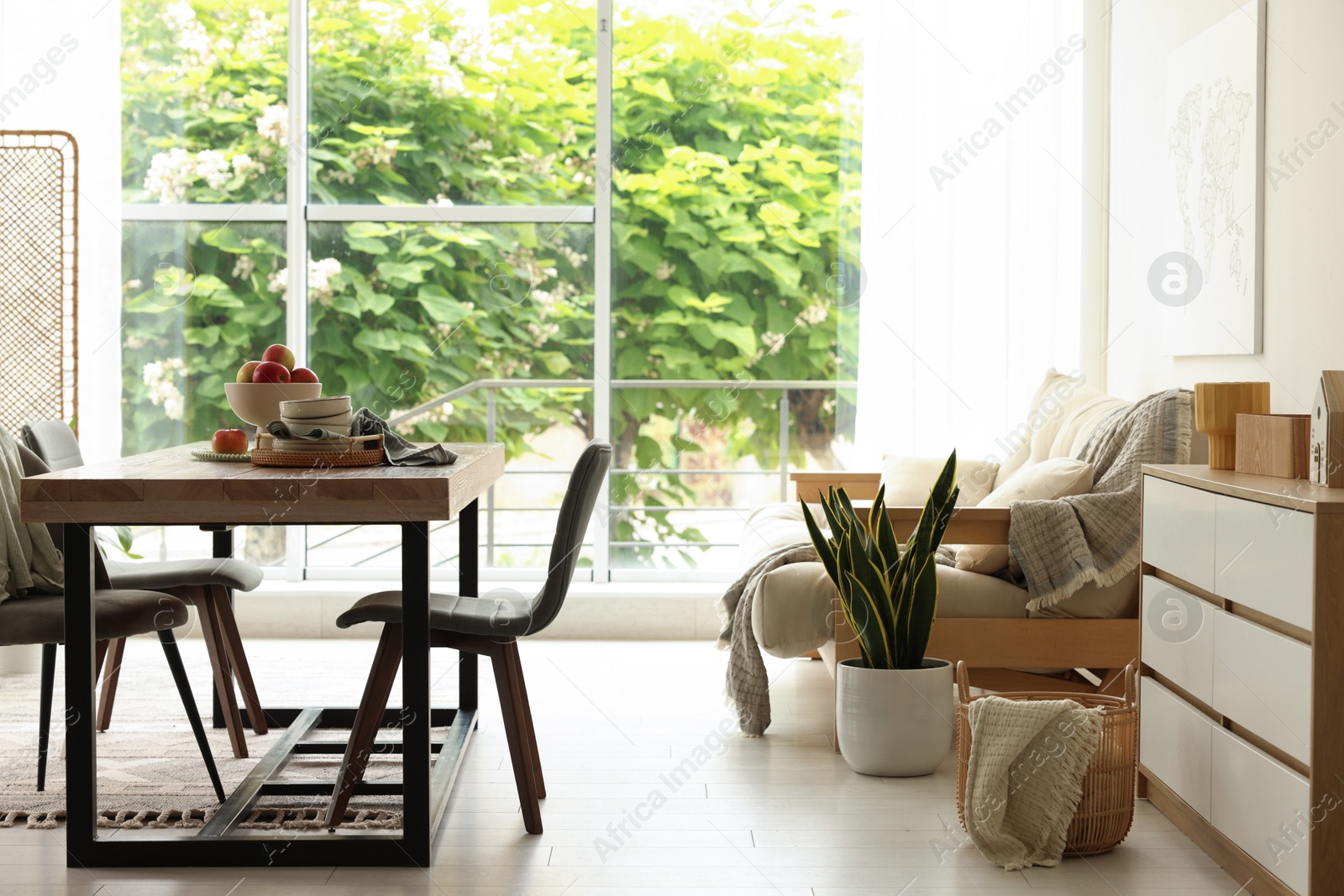 Wooden table, chairs, sofa and decor in dining room. Interior design Photo of Wooden table, chairs, sofa and decor in dining room. Interior design